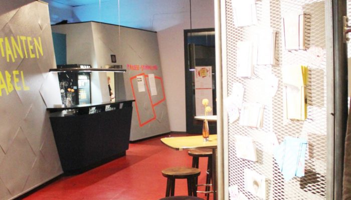 Foyer Theaterfoyer in Bahrenfeld, mit Getränketresen, Pinnwand für Aushänge, Stehtischen und Barhockern.