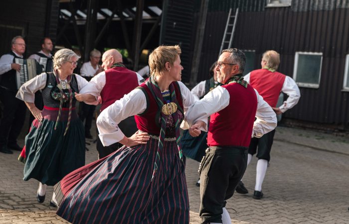 2 Gutes aus Hamburger Landen © Isabel Machado Rios Eine Trachtengruppe tanzt vor einem Kuhstall